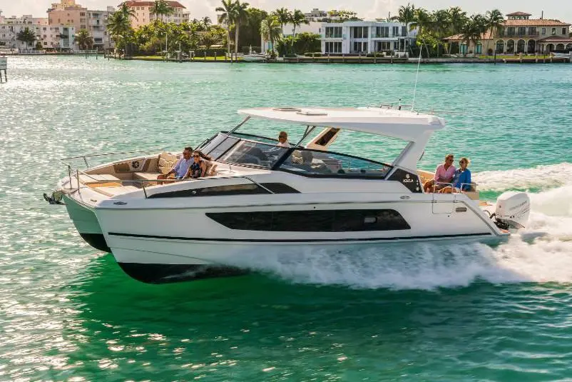 Luxury motorboat cruising in turquoise water, with passengers enjoying the ride and tropical homes in the background.